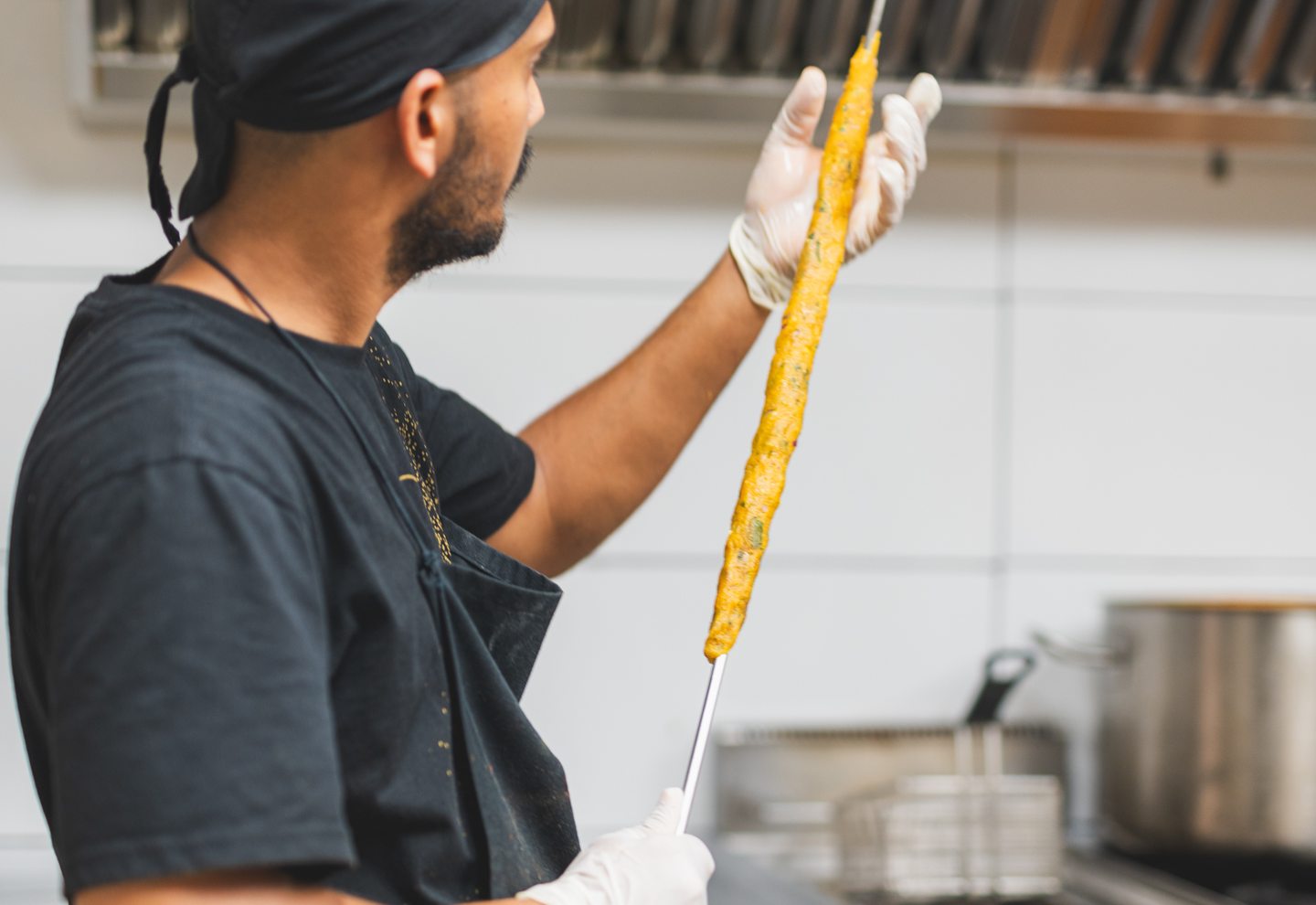 Cocinero de Mr Singh cargando brochetas para el tandoor