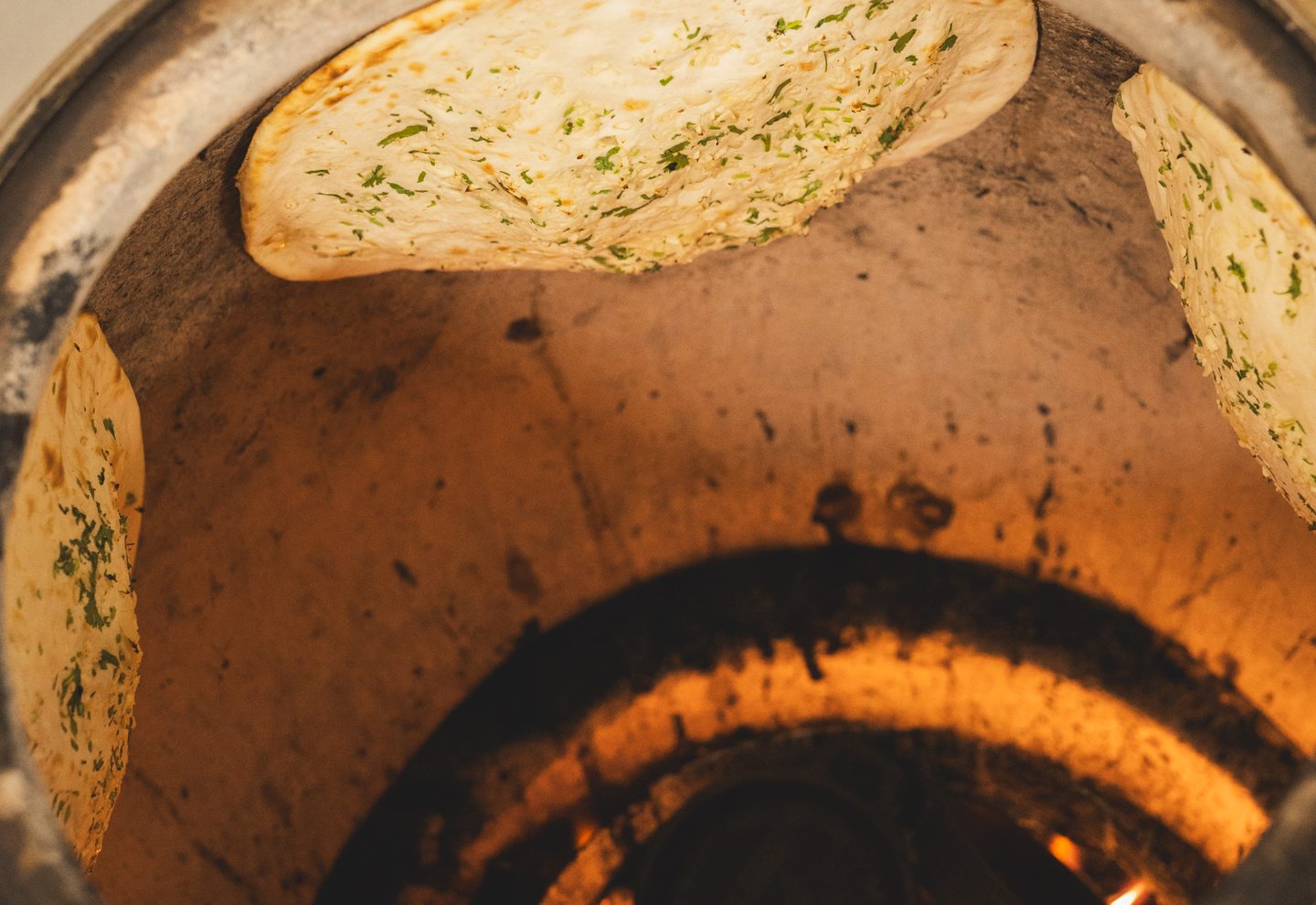 Naan cociéndose dentro del tandoor de barro de Mr Singh